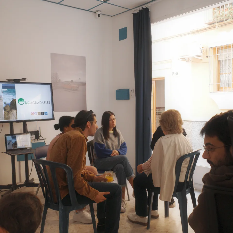 Taller en Espacio La Tesela: grupos de personas trabajando con fichas alrededor de las mesas de madera